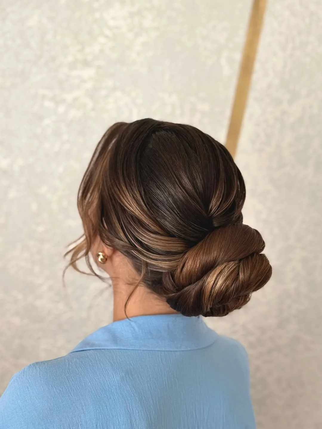 natural summer bun hairstyles 2026 Dimensional Low Bun With Glossy Ribbon Highlights