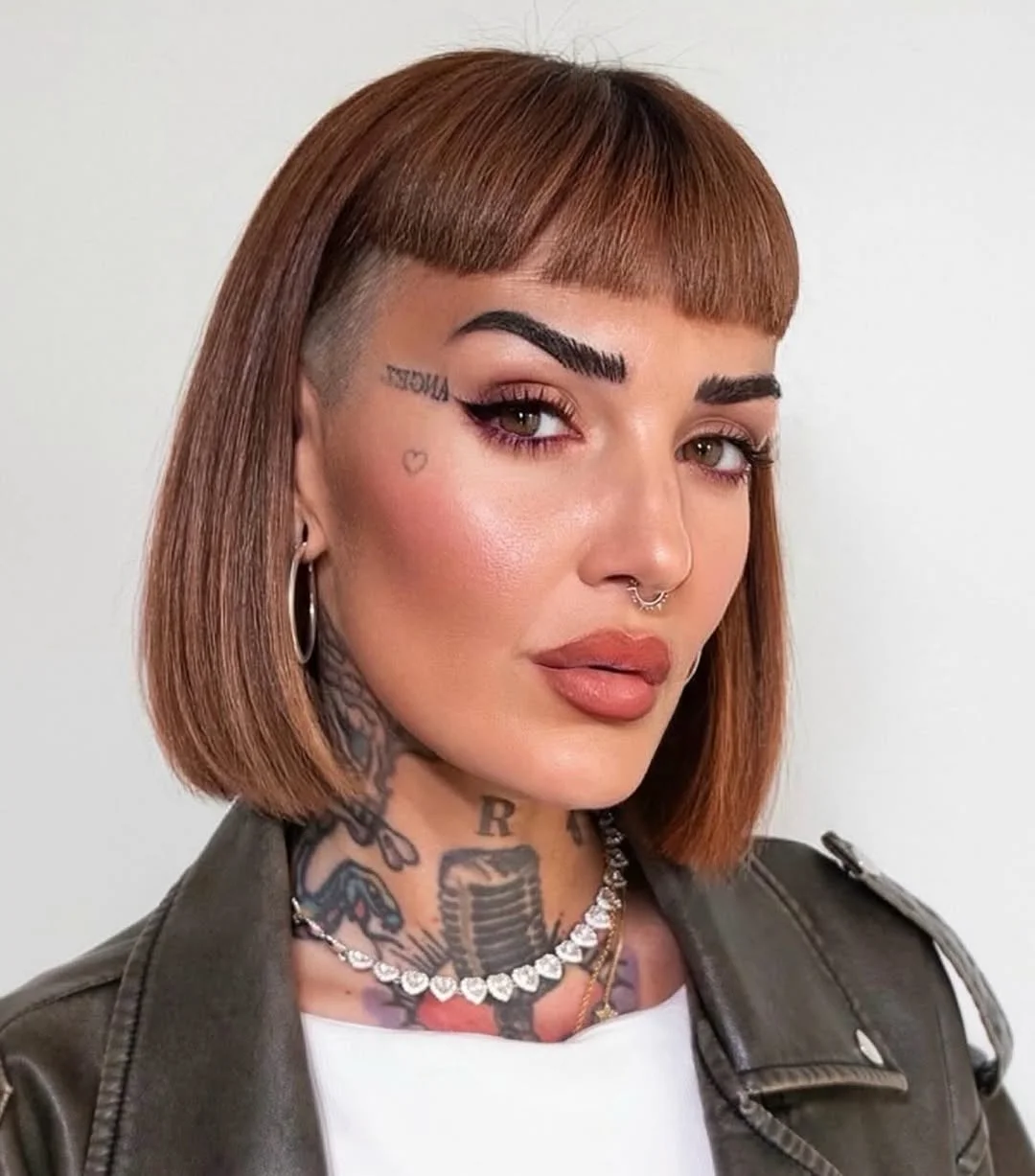 salon summer short haircuts 2026 Structured Copper Bob With Graphic Baby Bangs