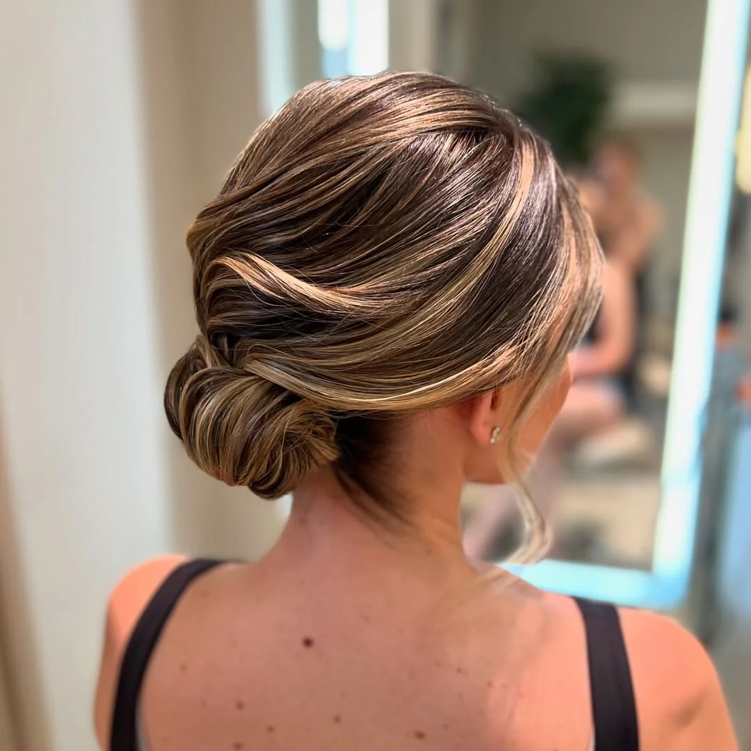 sleek summer updo hairstyles 2026 Soft Espresso Low Bun With Face-Framing Highlights