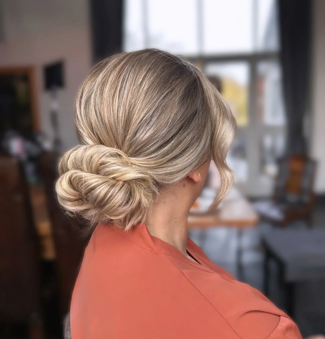 stylish summer haircut for round face 2026 Low Twisted Summer Bun With Face-Framing Pieces