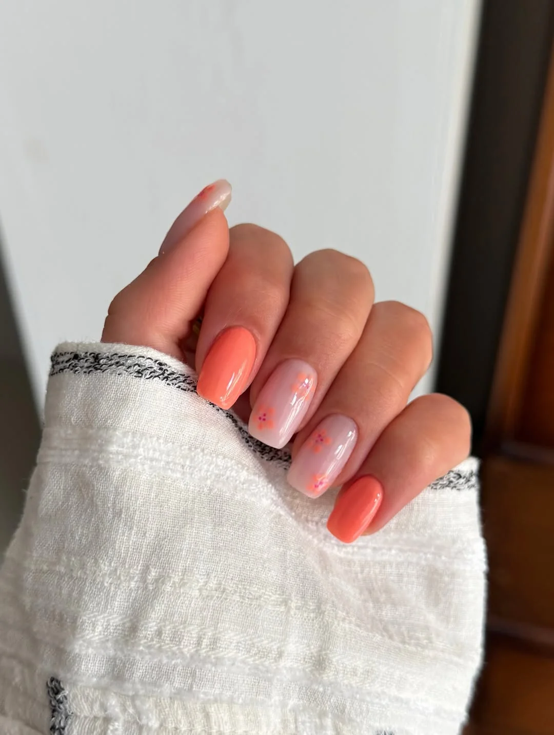 summer toe nails colors 2026 Peachy Coral Nails With Soft Minimal Floral Details