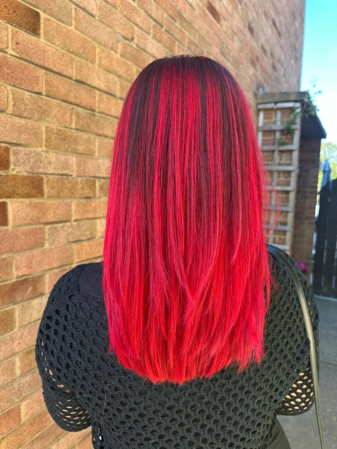 trendy summer red hair color 2026 High Contrast Red Melt with Dark Roots Drama
