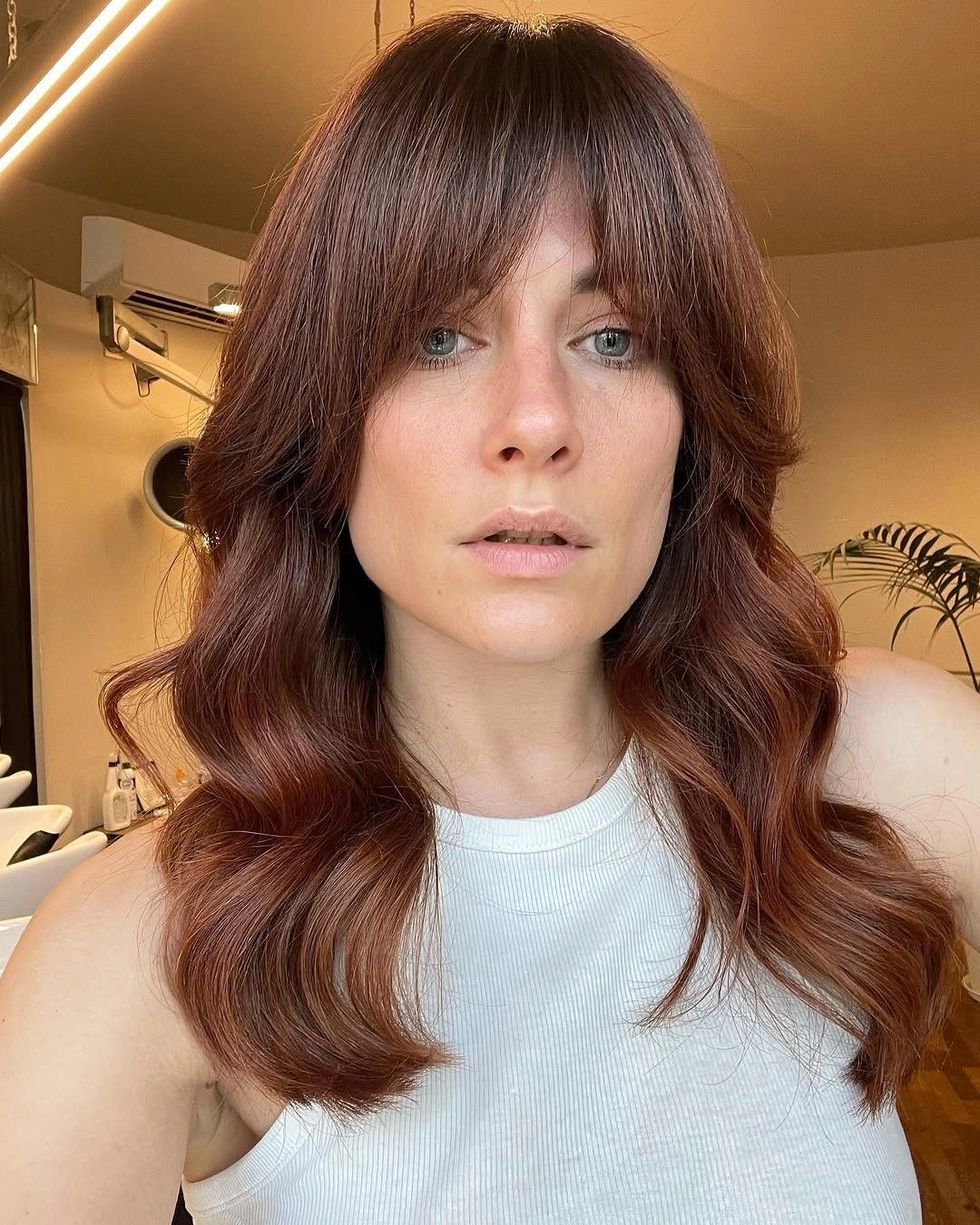 august hairstyles and color ideas 2026 Warm Cinnamon Waves With Soft Curtain Bangs