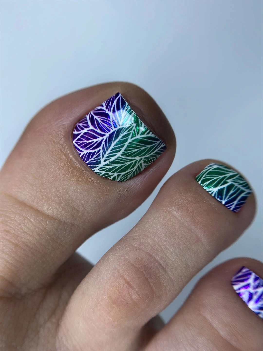 august pedicure nails ideas 2026 Holographic Tropical Leaves for a Vacation Finish