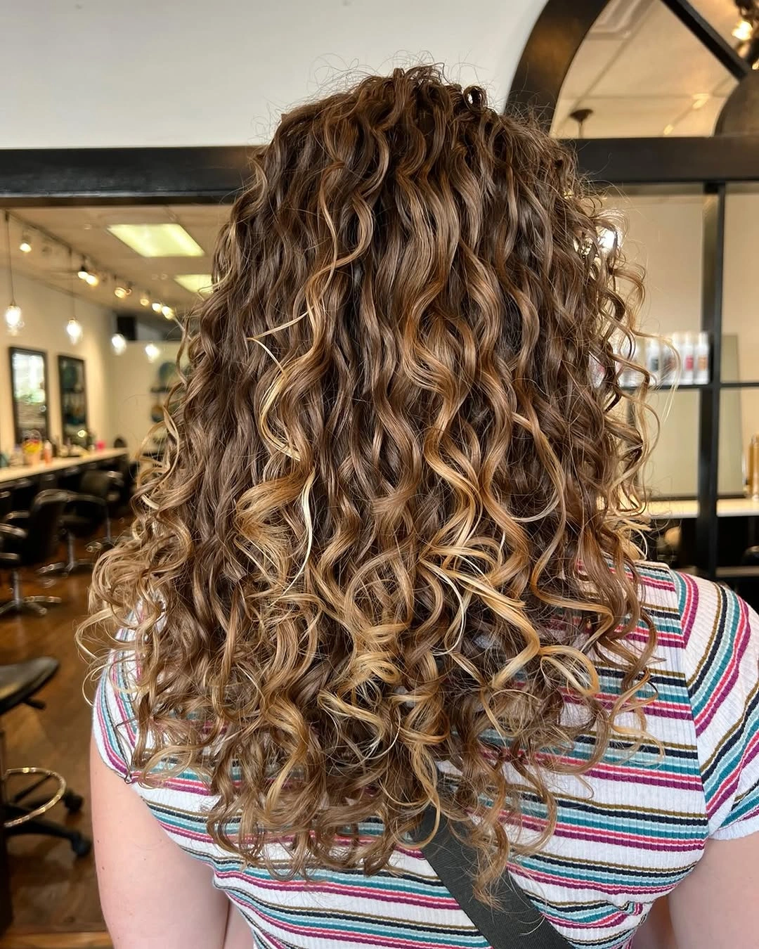 fall haircuts for women 2026 Defined Caramel Curls Full of Dimension