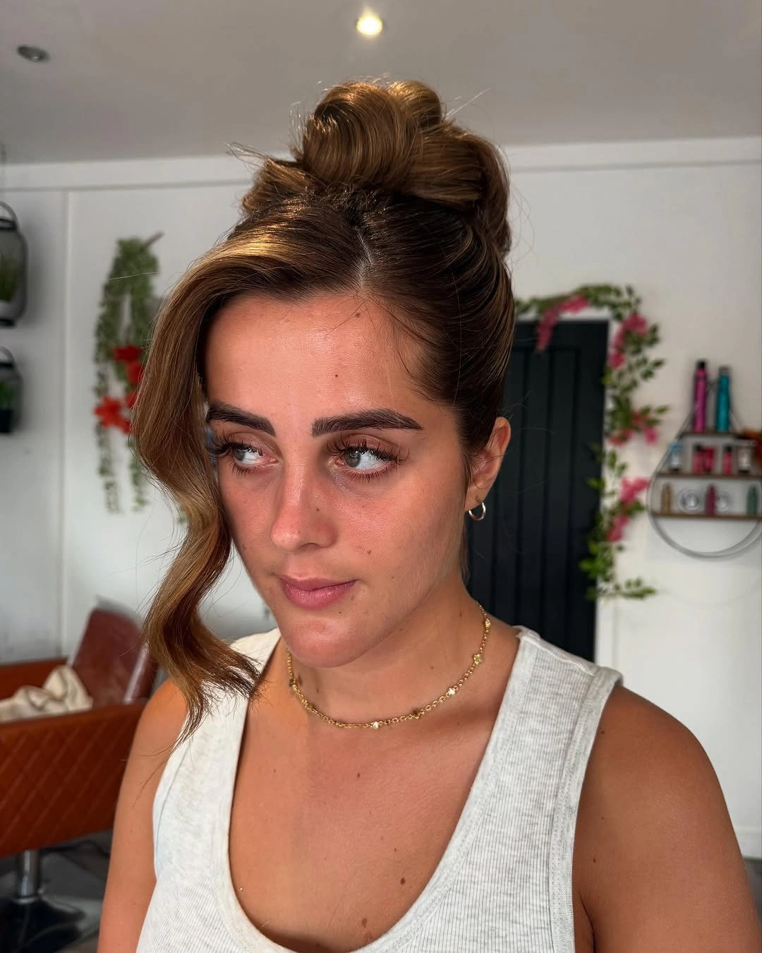 Fall hairstyles for wedding guests 2026 Side-Swept High Bun With Vintage Hollywood Wave
