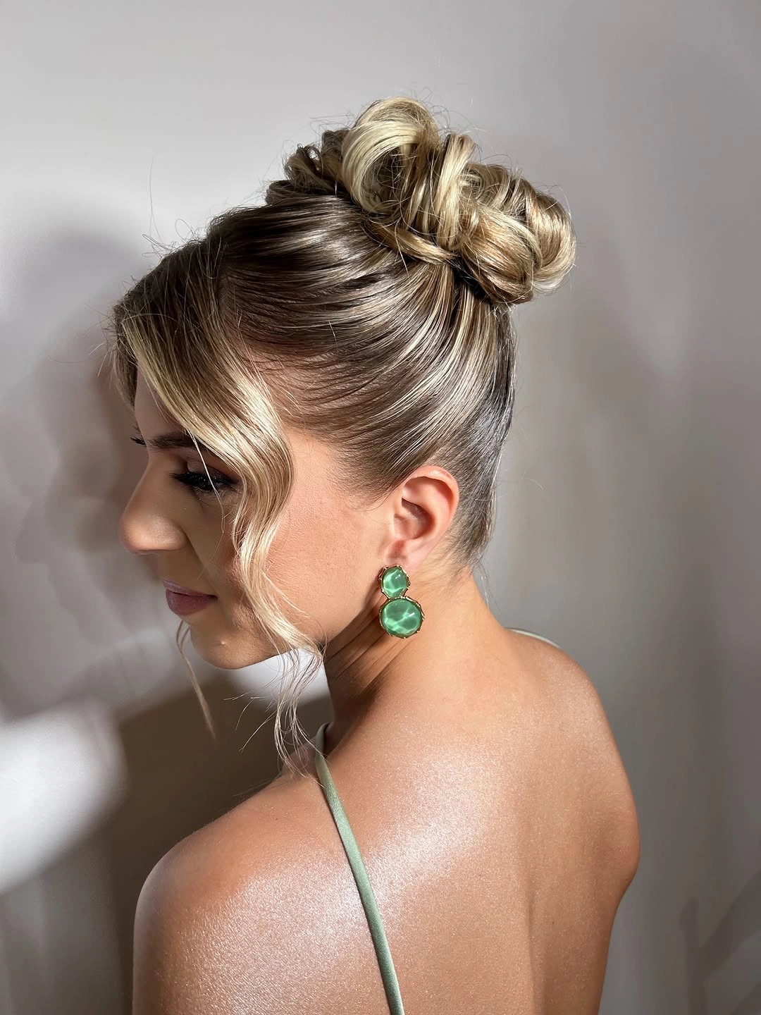 Fall hairstyles for wedding guests 2026 Polished High Bun With Soft Blonde Face-Framing Wave
