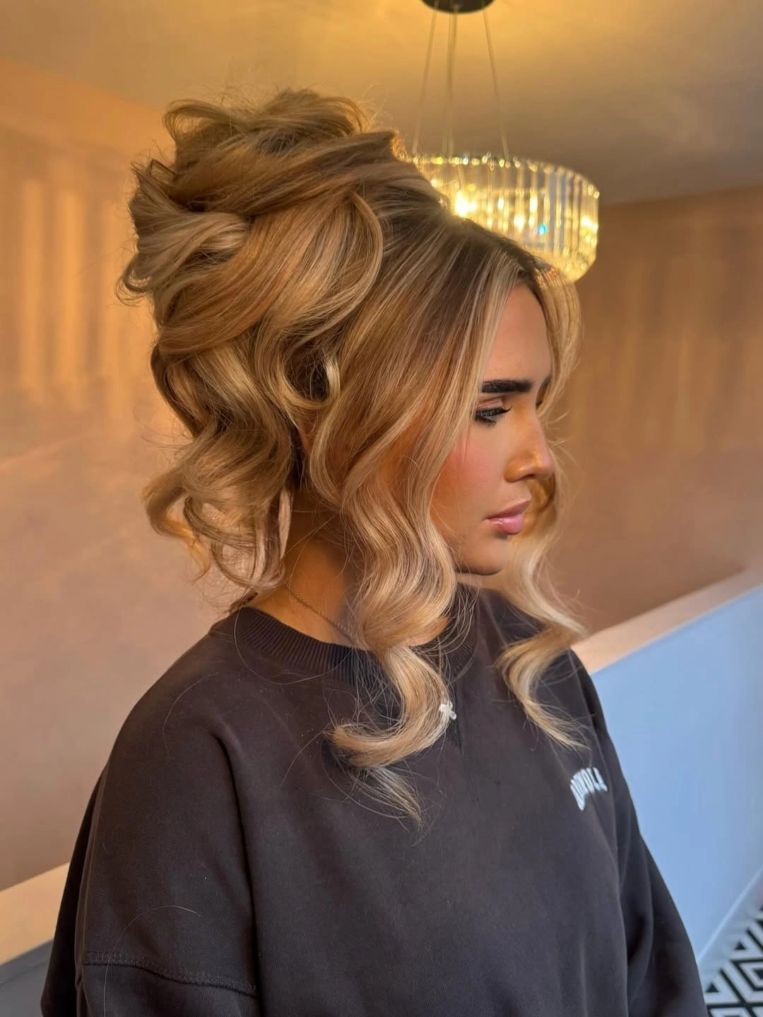 Fall hairstyles for wedding guests 2026 Voluminous Blonde Updo With Loose Romantic Curls