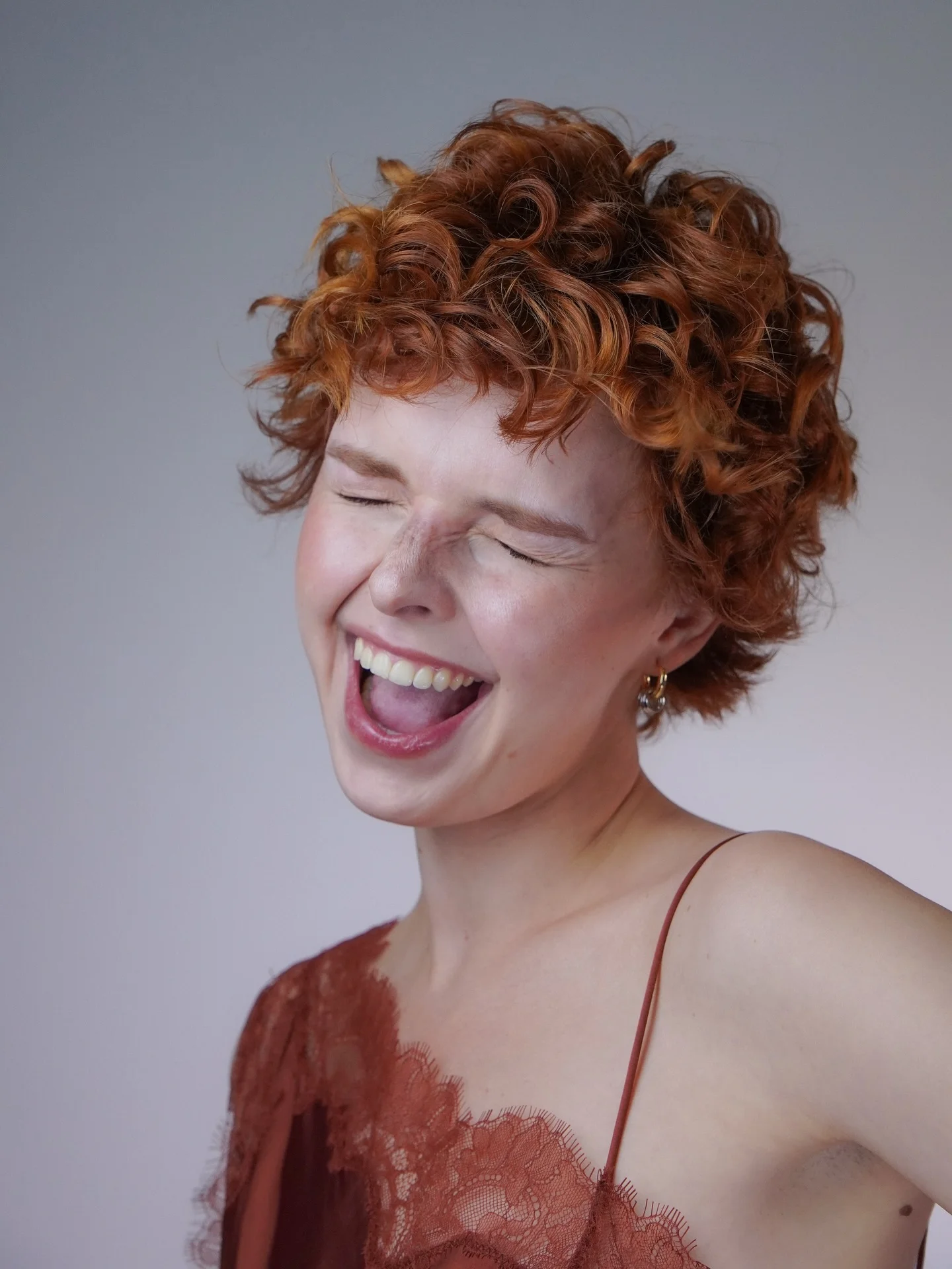 fall short haircuts 2026 Playful Copper Curly Pixie Full of Autumn Energy