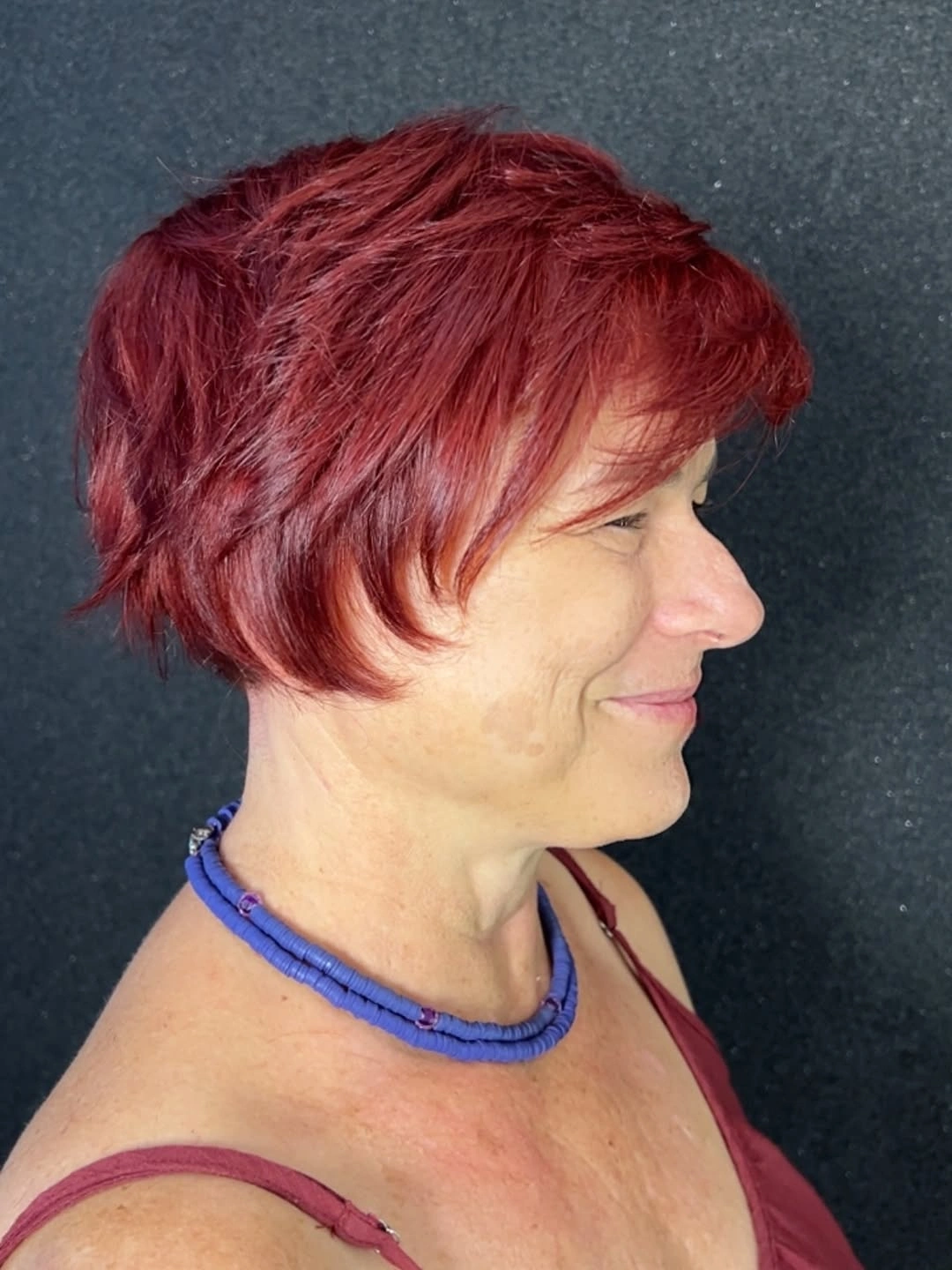 fall short haircuts 2026 Layered Burgundy Pixie With Feathered Movement