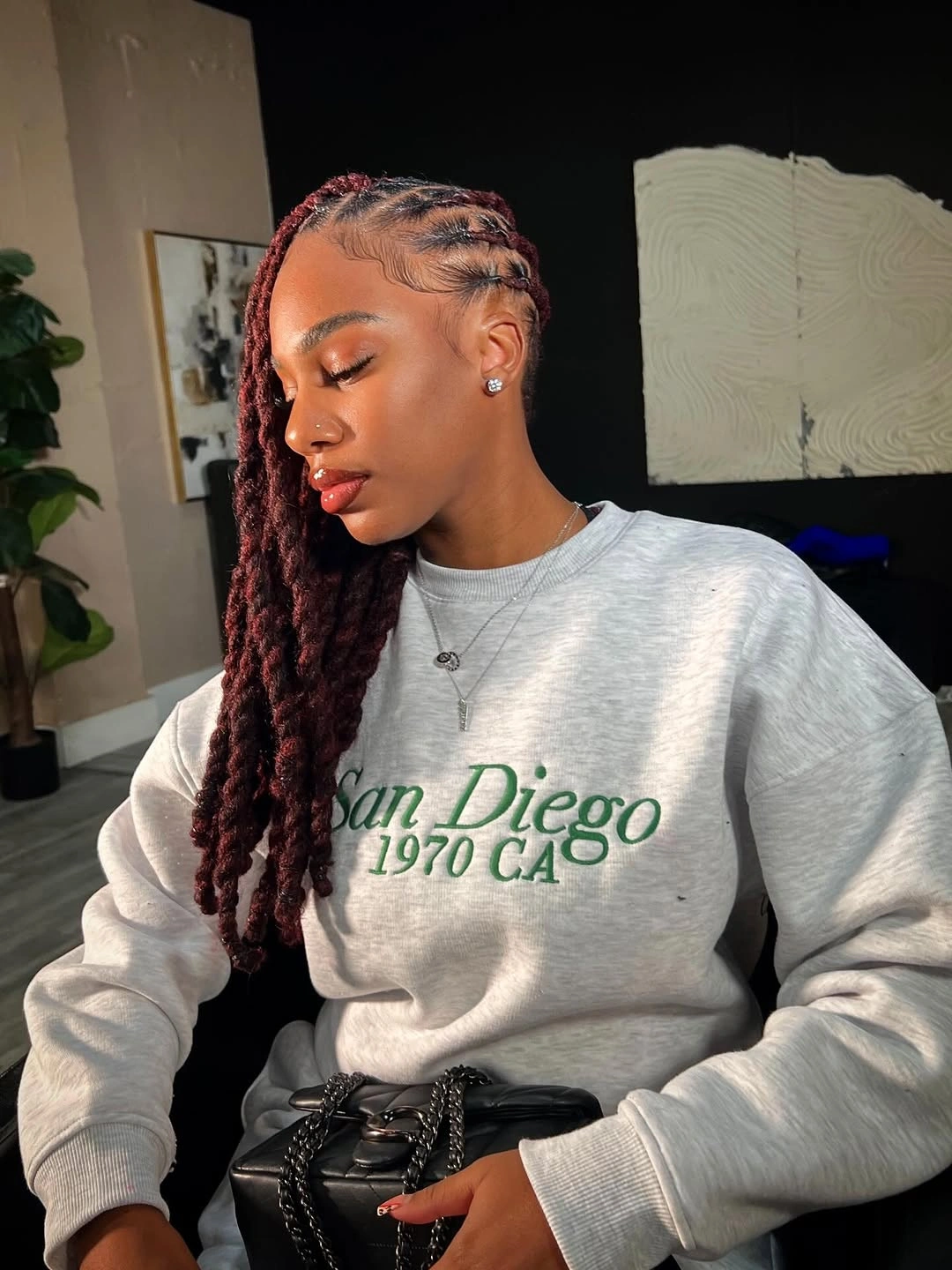 locs hairstyles for black women Side-Swept Burgundy Locs with Sleek Cornrow Detail