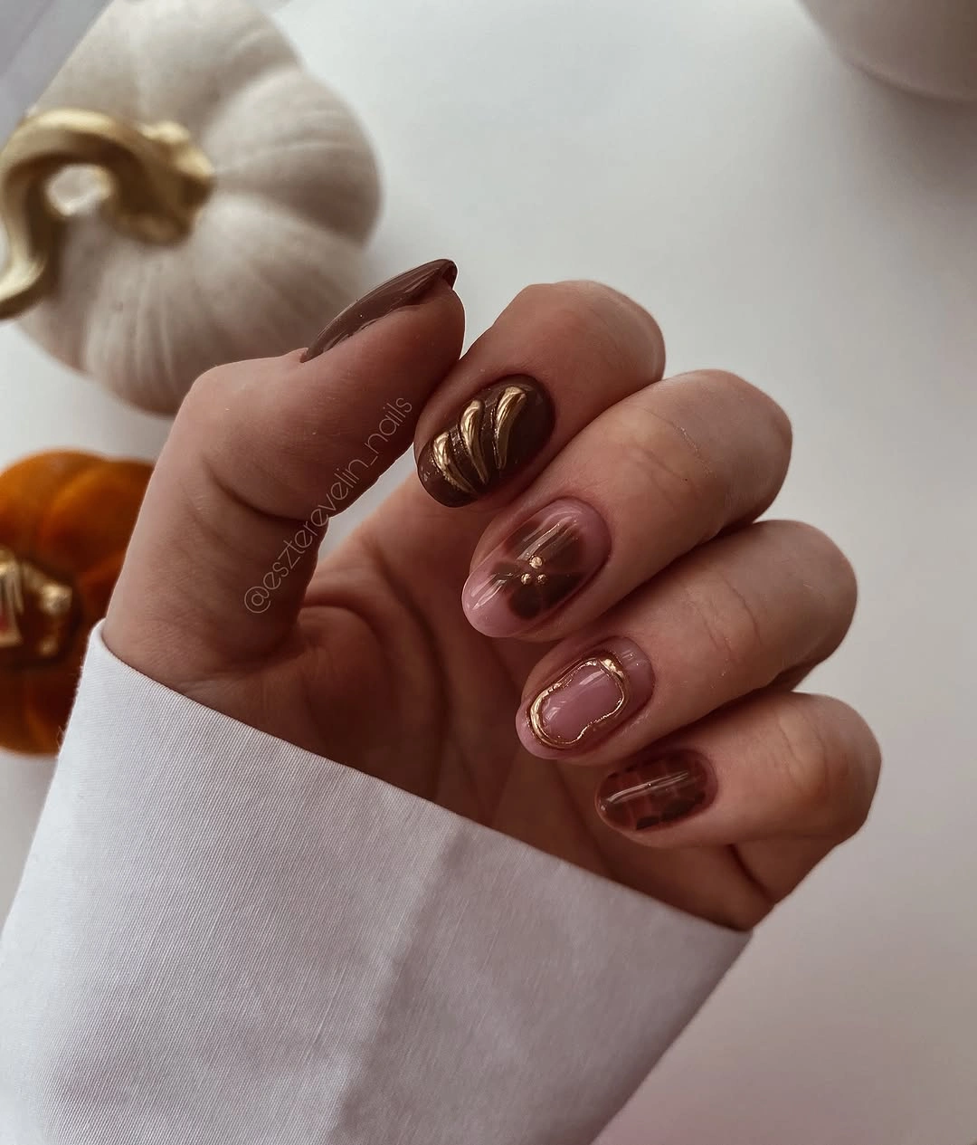September nail art ideas 2026 Glossy Brown Nails With Metallic Swirl Accents