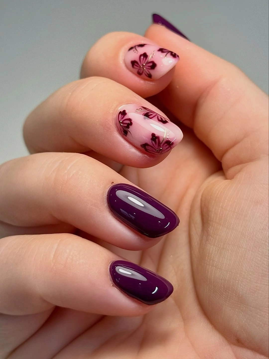 Short oval plum autumn nails with small floral accents
