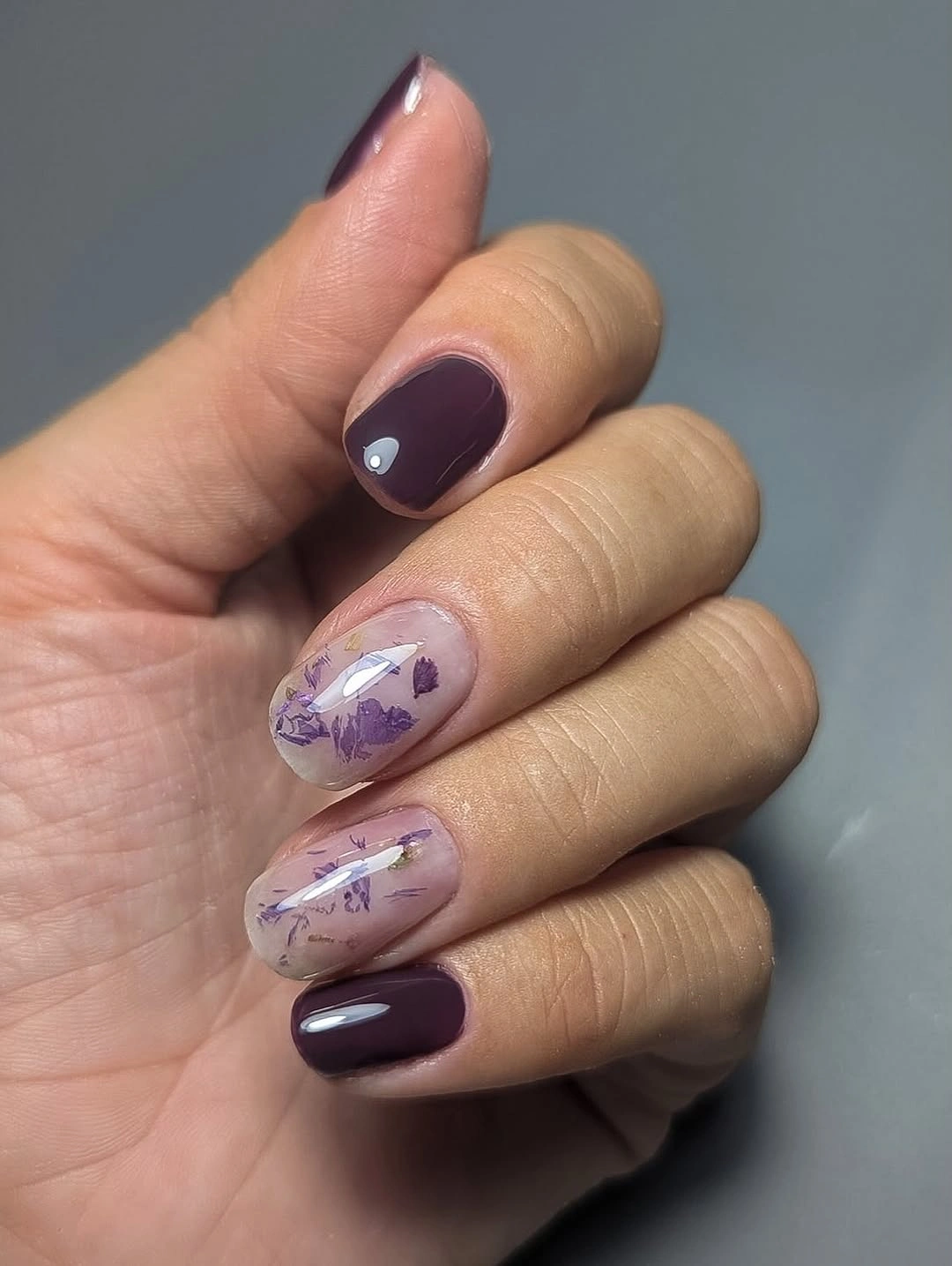 Short rounded plum autumn nails with translucent purple accents
