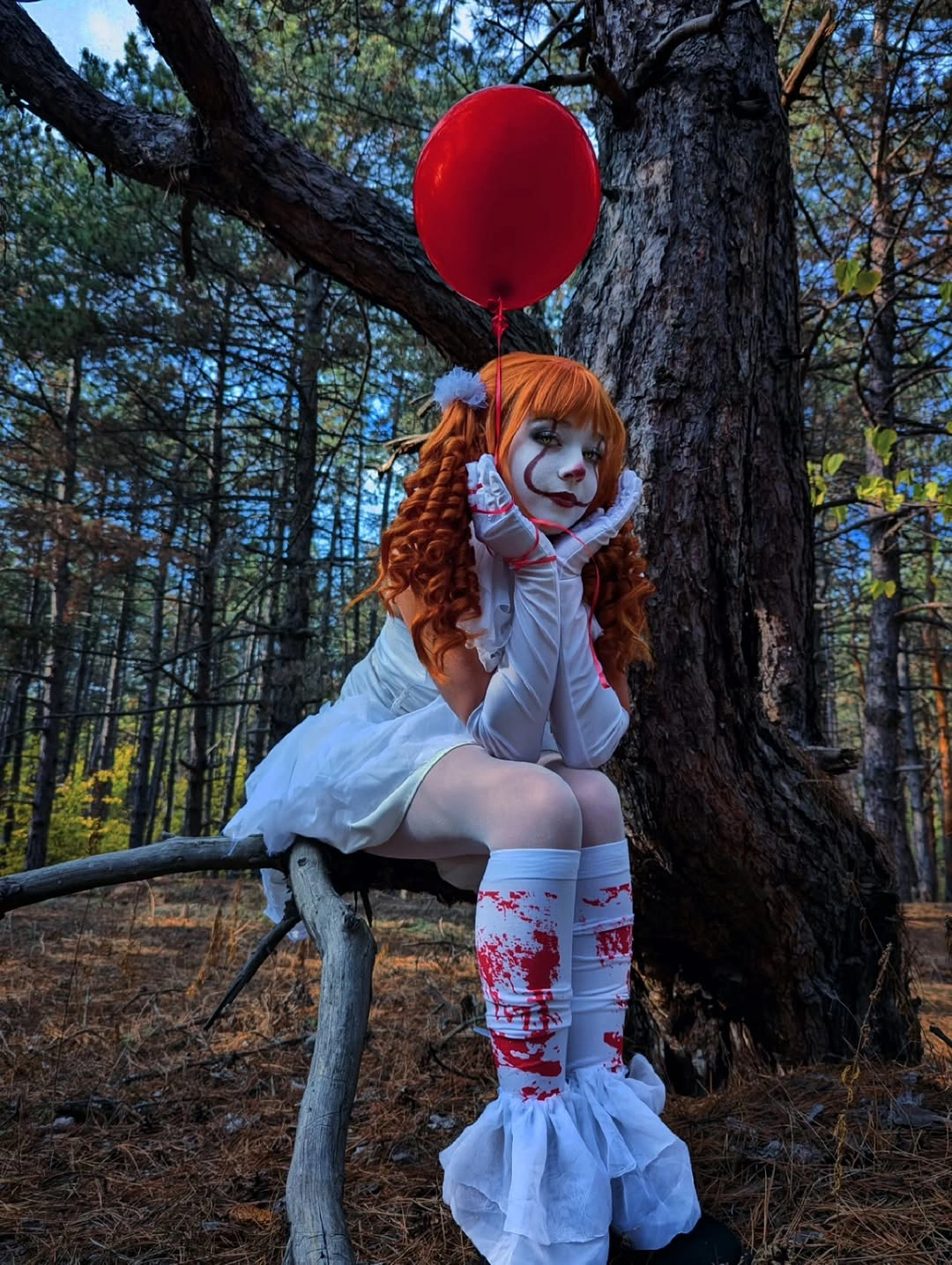 White ruffled clown dress with red balloon red hair and patterned knee socks
