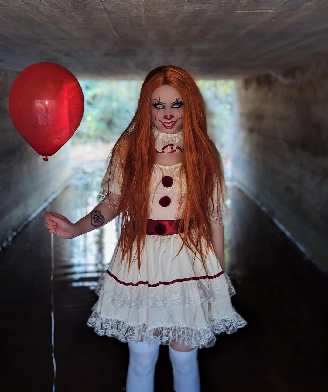 White ruffled clown costume with red pom-poms red hair and balloon