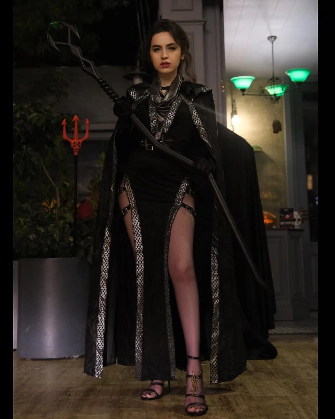 Black gothic costume dress with high slit dark boots and trident prop