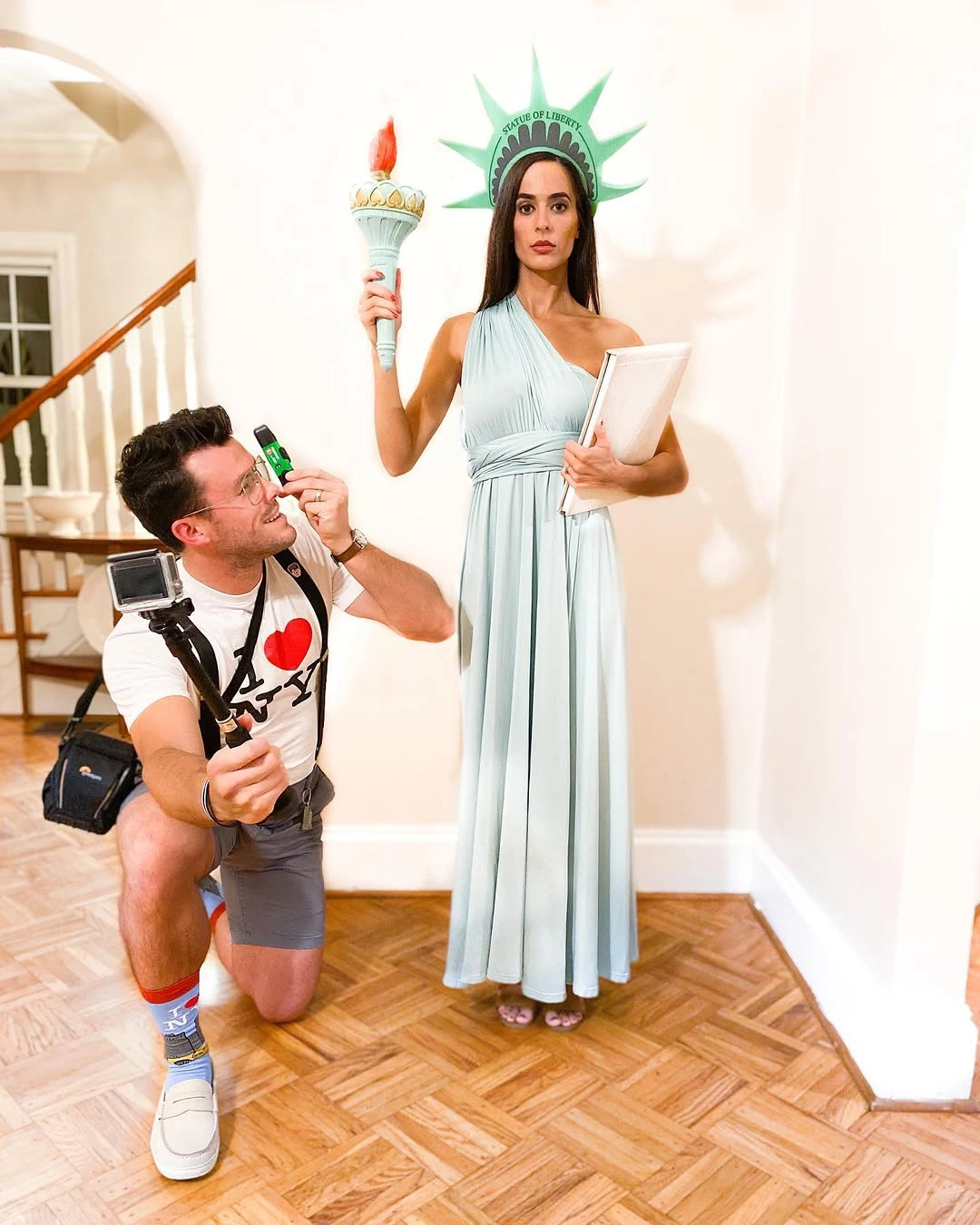 Couple costume with pale draped dress crown torch and casual partner outfit