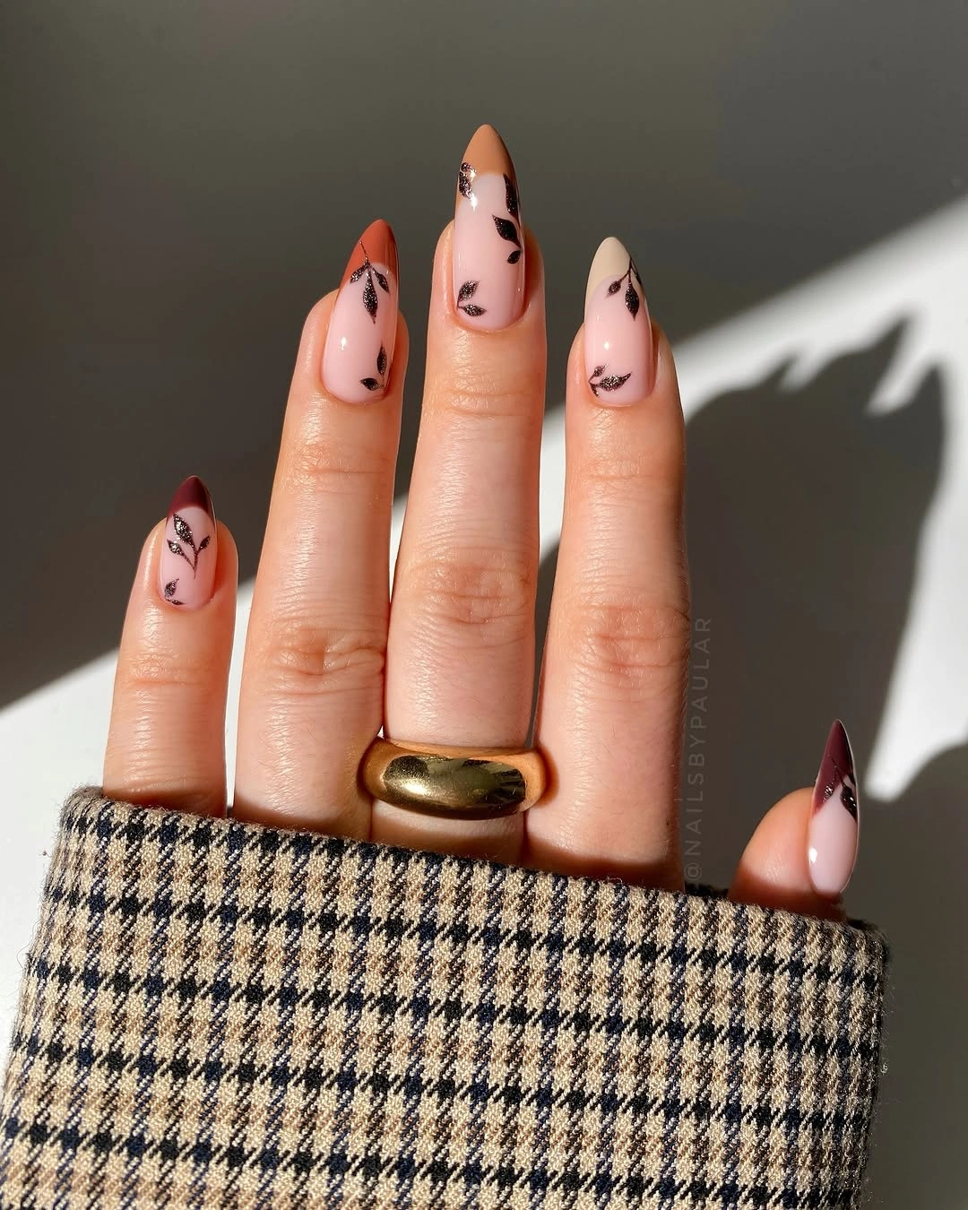 Long almond nude nails with loose dark brown tip marks