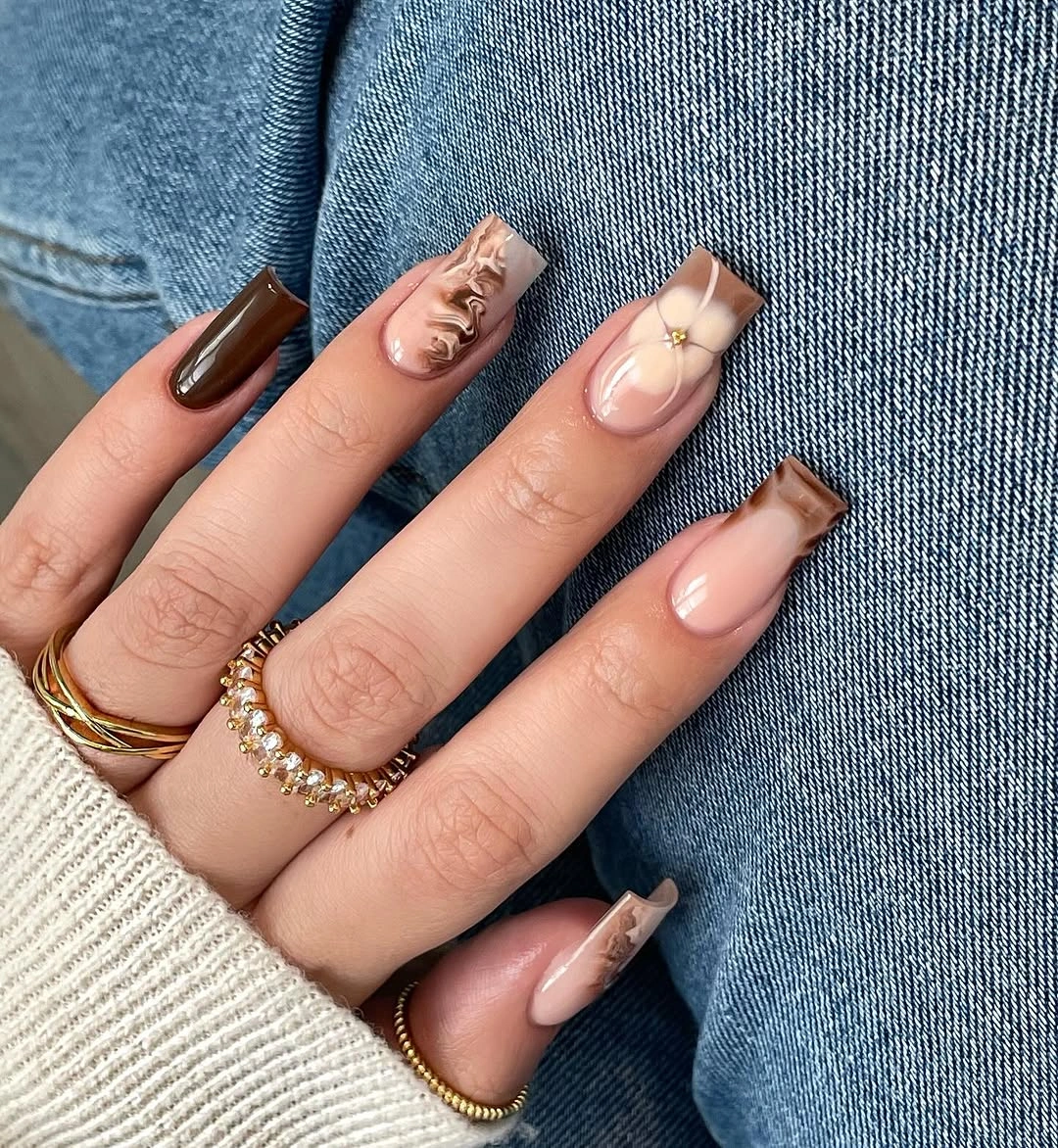 Long square nails in brown and pale pink with tiny gold accents
