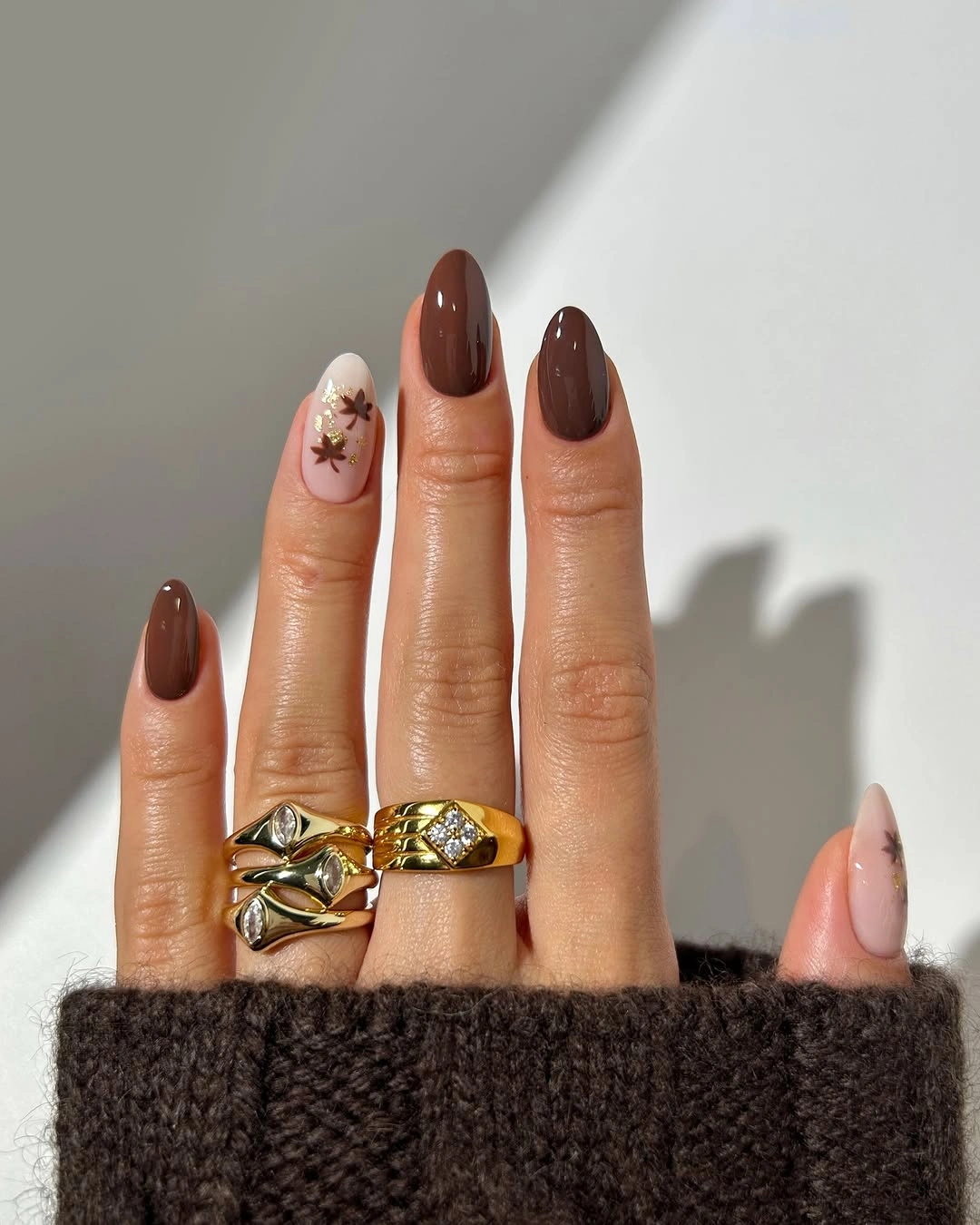 Long almond chocolate brown nails with pale nude and small gold accents