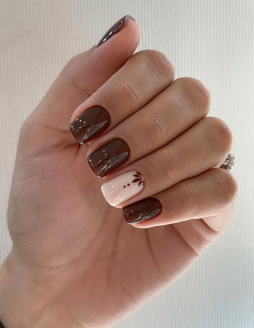 Medium square chocolate nails with one pale pink patterned accent
