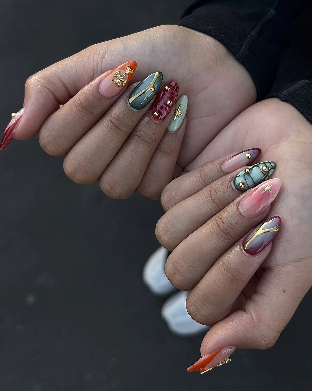 almond nails mixing jewel tones with fine gold accents