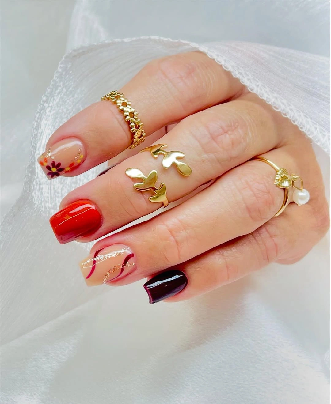 Red plum and nude square nails with floral accents