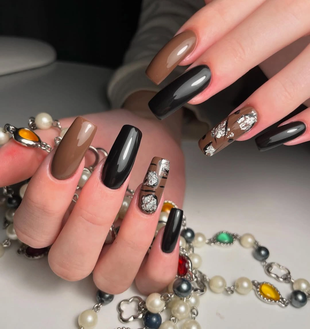 Glossy black and brown square nails with abstract accents