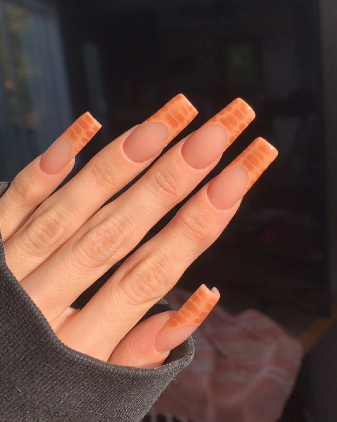 Long nude square nails with orange textured tips