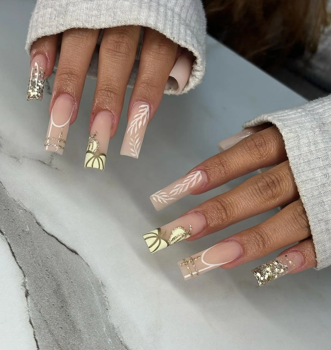 Nude square nails with botanical lines and gold tips