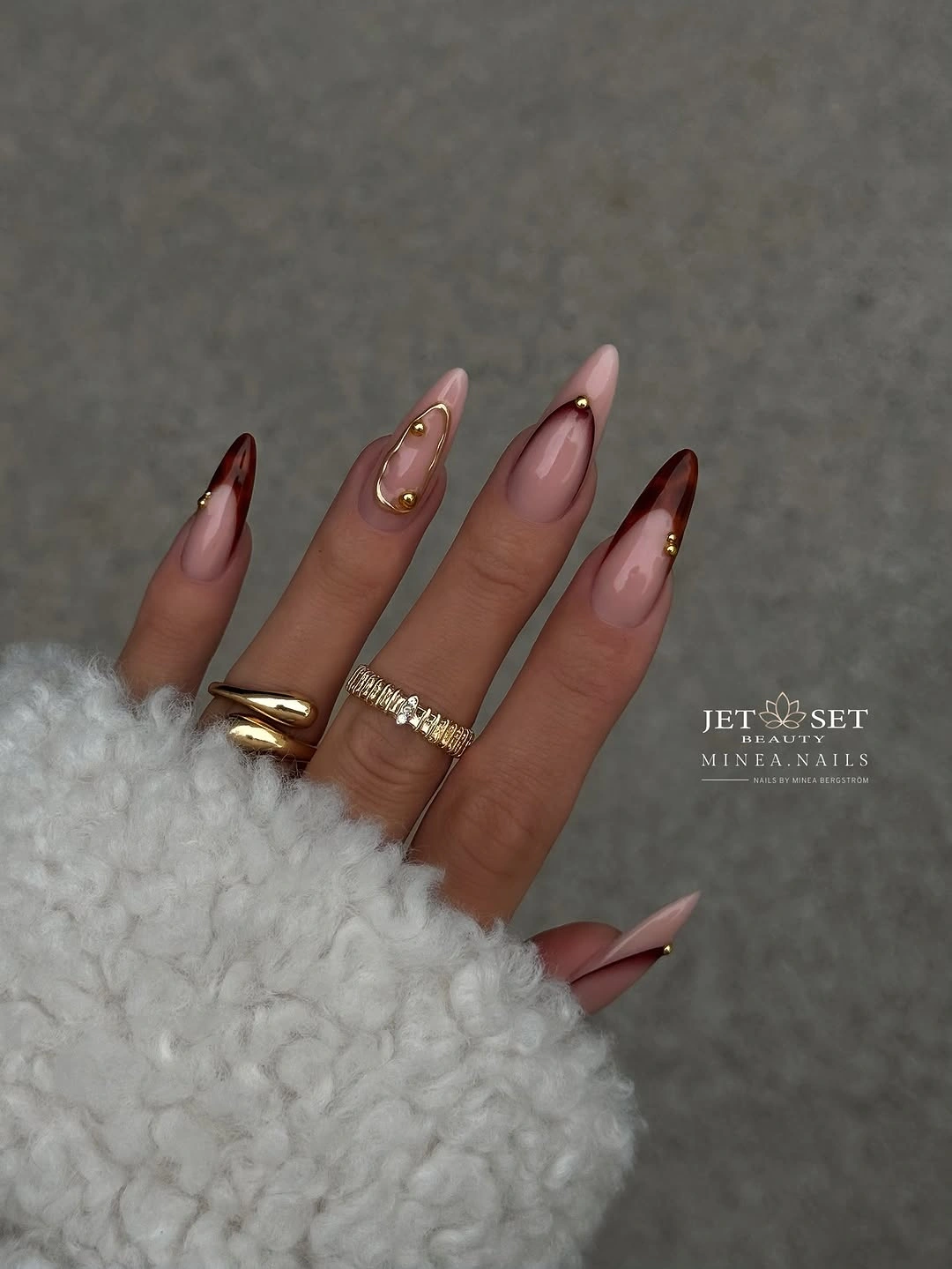 Long almond nails with diagonal brown tips and gold beads