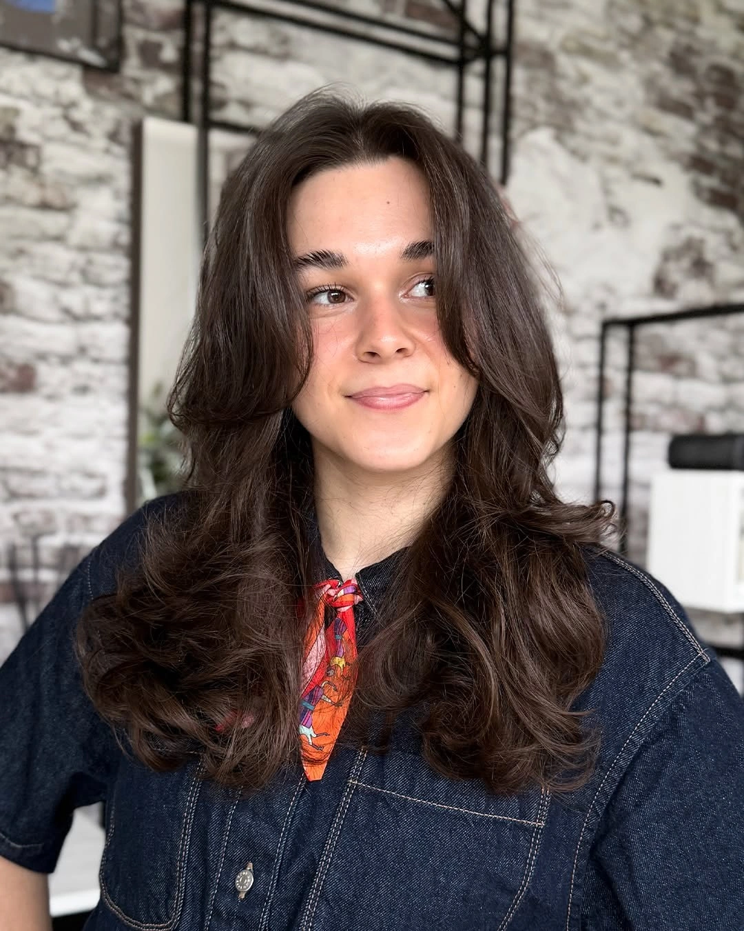 Bouncy dark brunette waves with soft lighter front reflections
