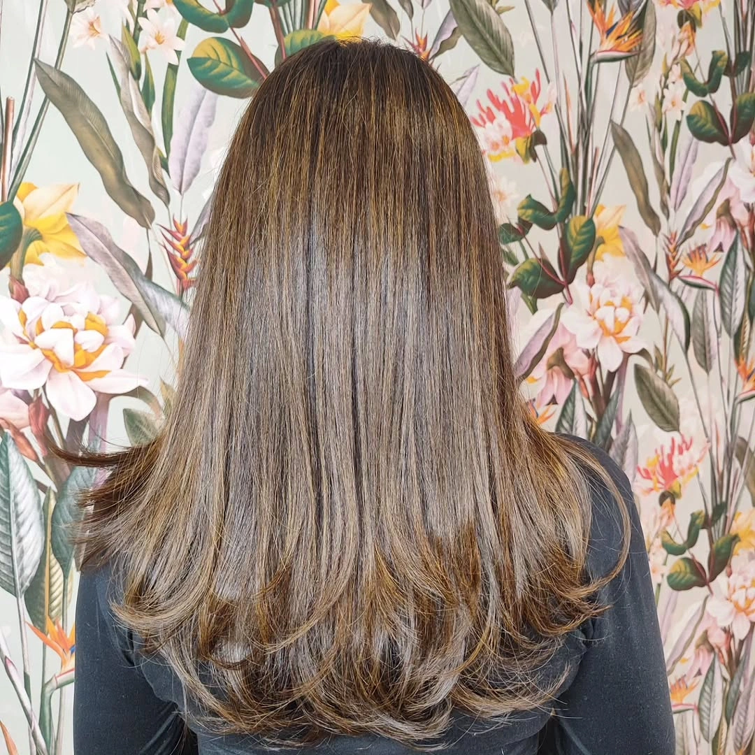 Sleek dark brown hair with a blunt shoulder length line