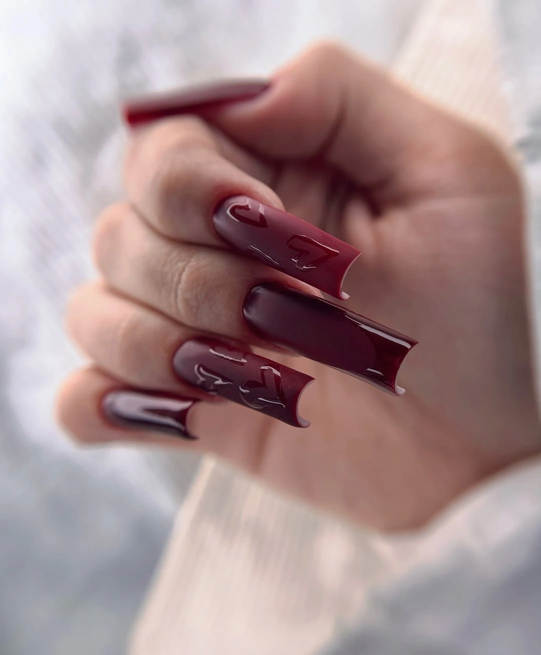 Long burgundy stiletto nails with tonal glossy swirls