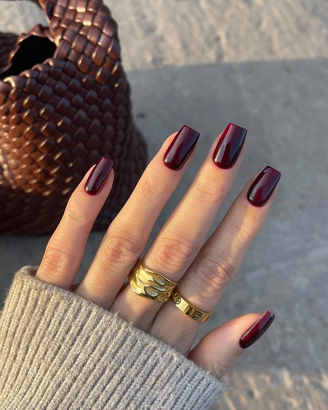 Medium burgundy square nails in warm outdoor light