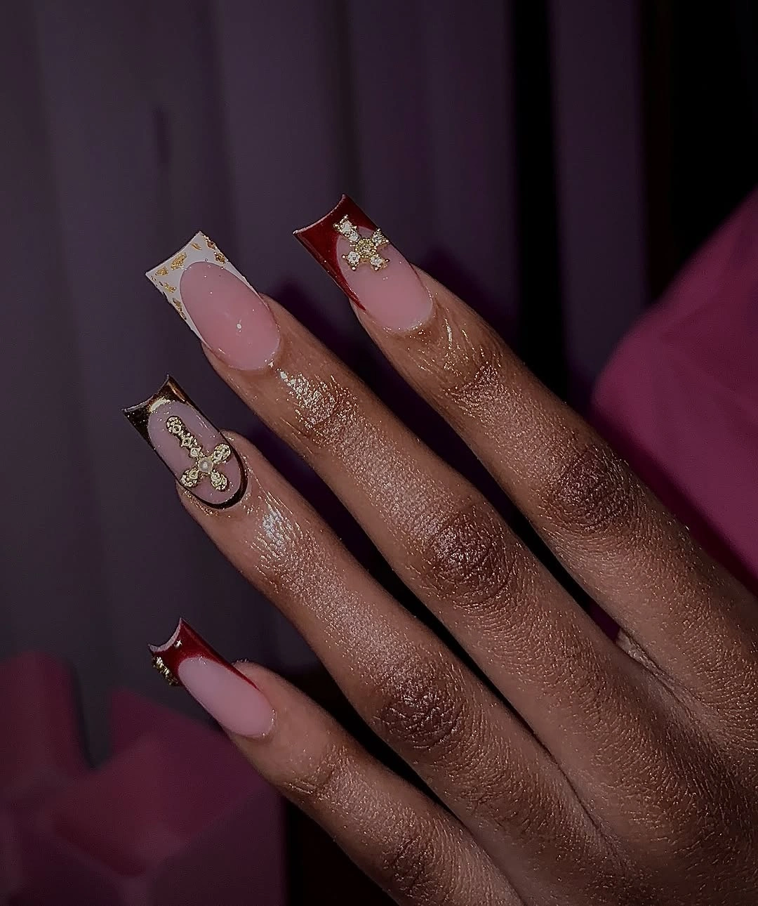 Long burgundy nude nails with gold decorative accents