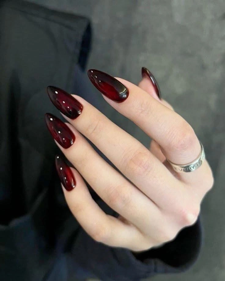 Long glossy burgundy stiletto nails with dark depth