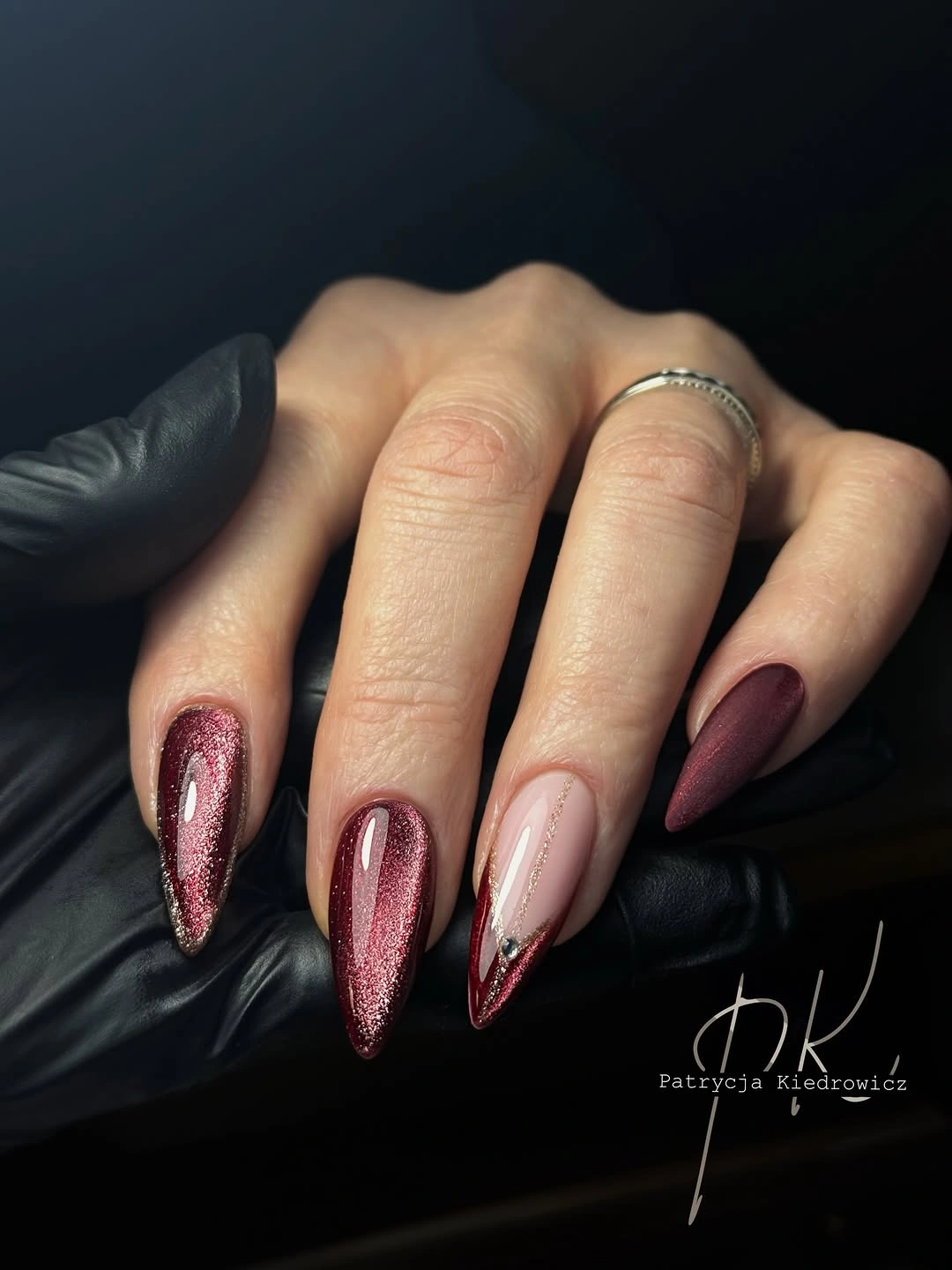 Long pointed burgundy nails with metallic shimmer