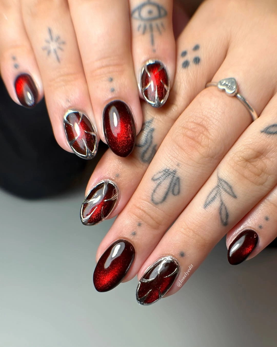 Red black almond nails with silver frames and reflective centers