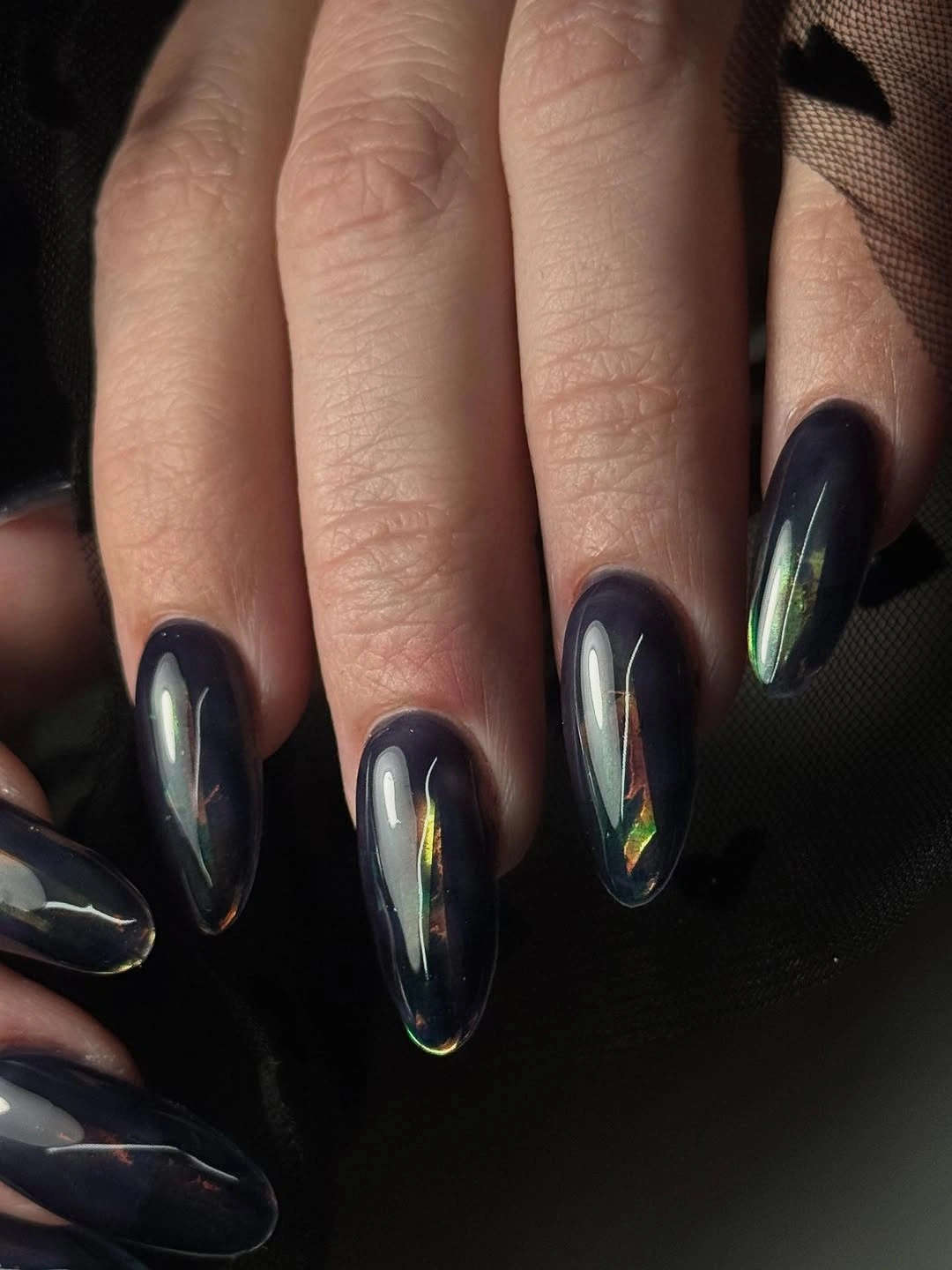 Long pointed blue black nails with iridescent reflective streaks