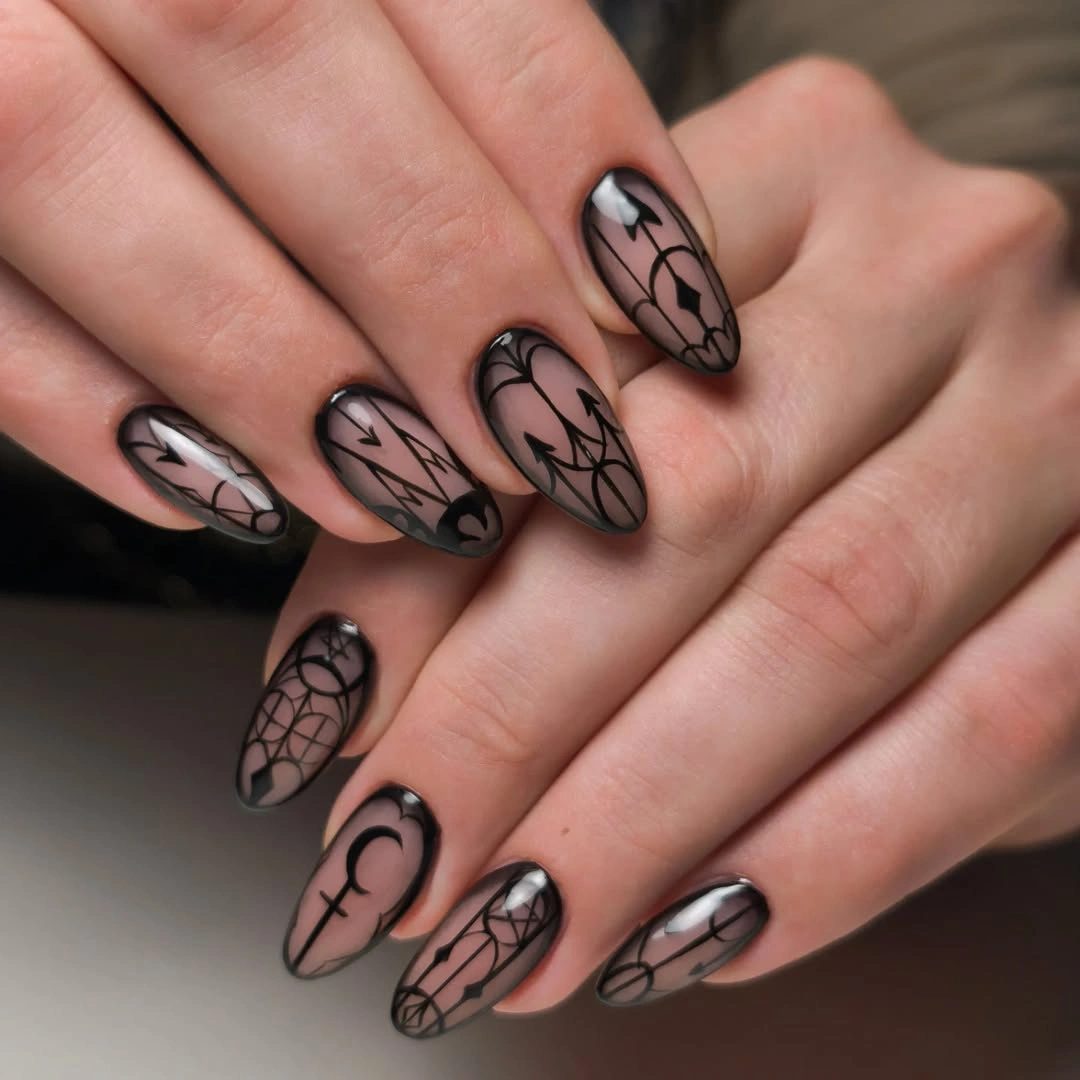 Medium almond nails with smoky nude bases and black botanical lines