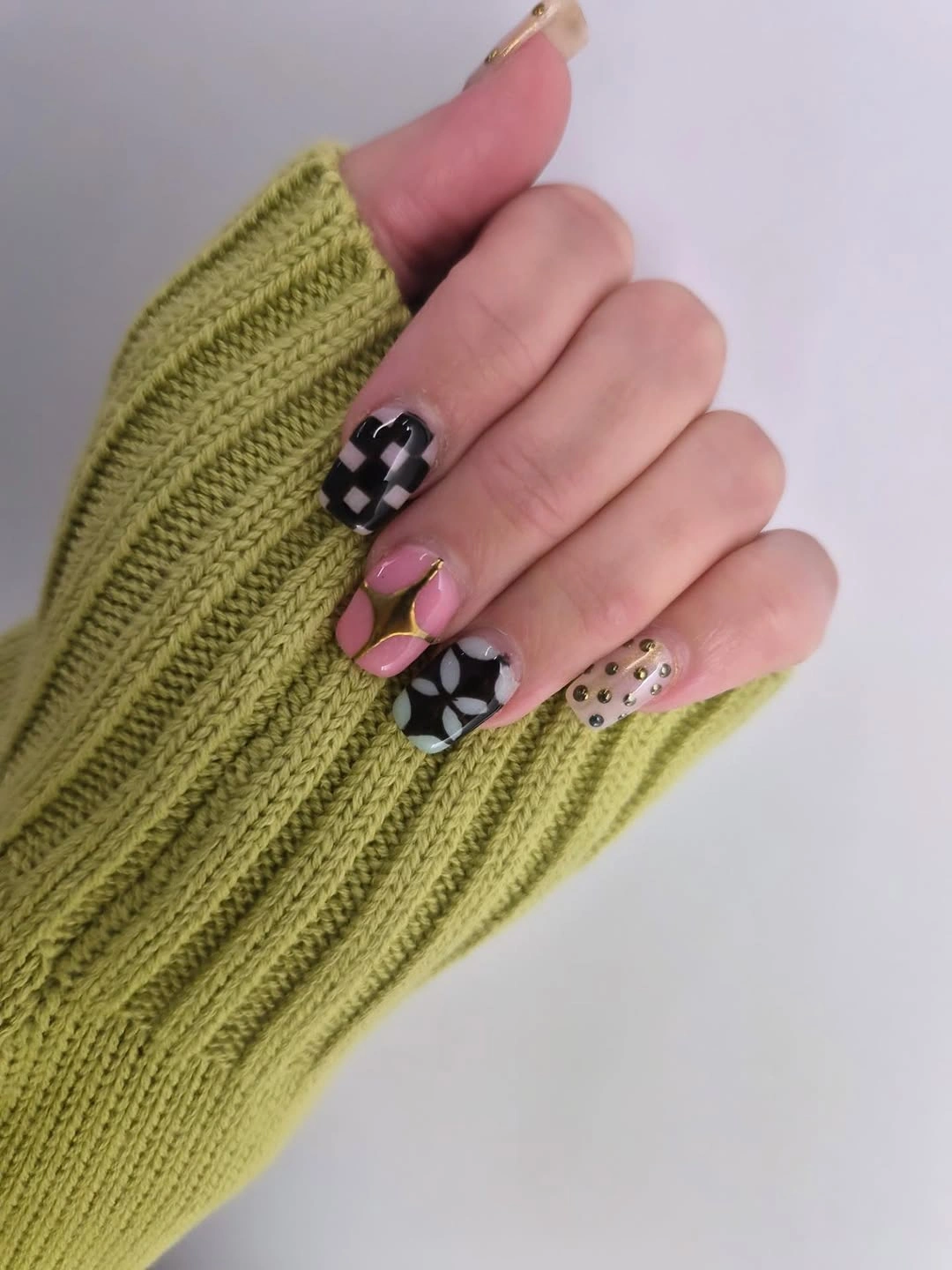Pale pink short nails with checkerboard and graphic black white accents