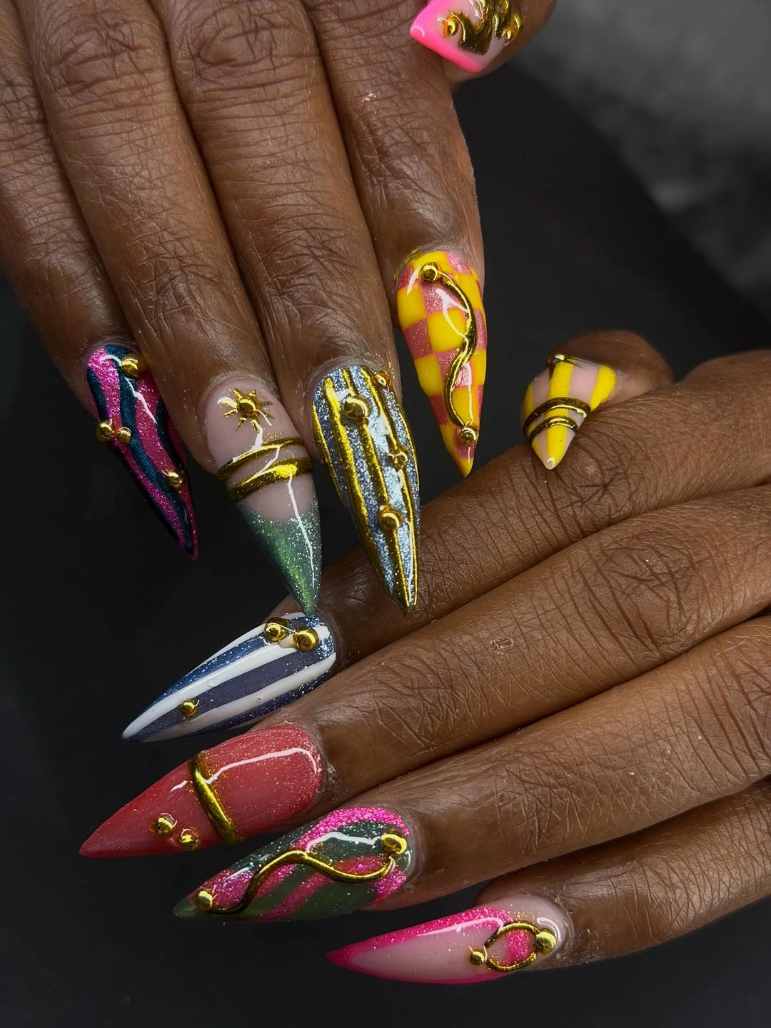 Long pointed multicolor nails with dark outlines and bright panels