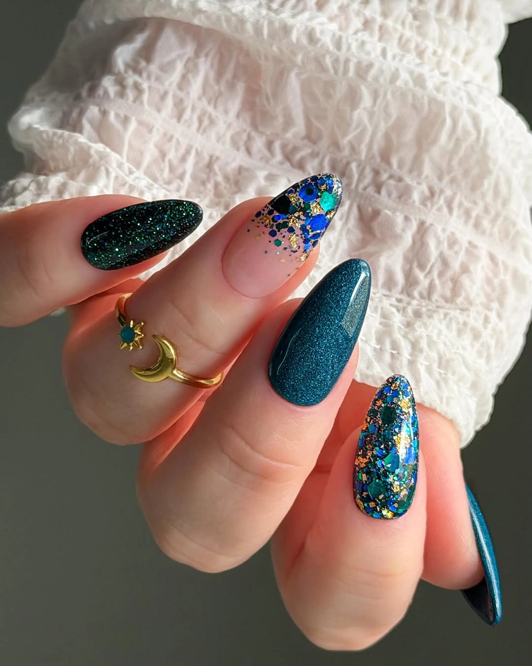 Long teal almond nails with blue floral and glitter accents