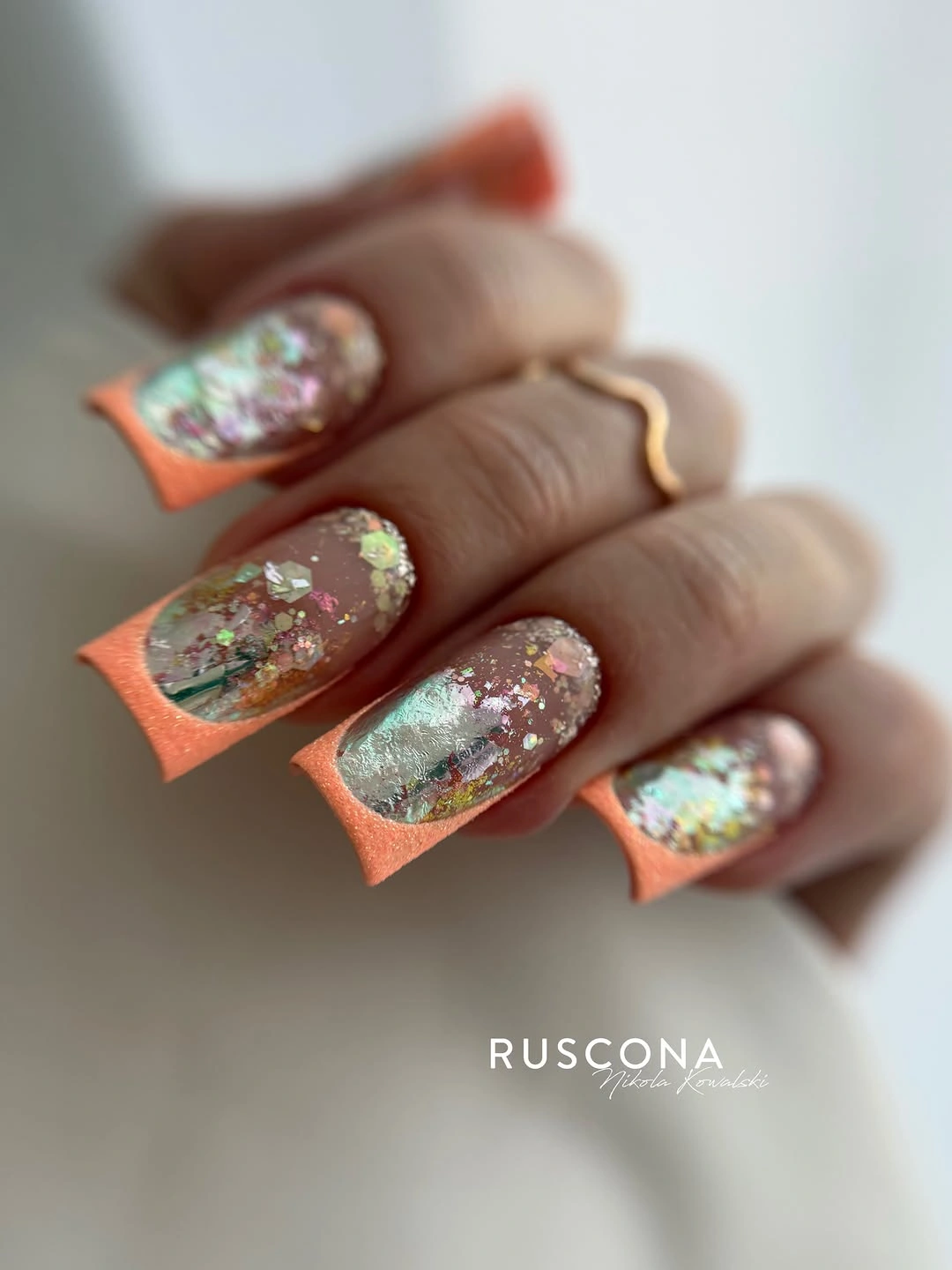 Peach coral and mint nails with glittery textured French accents