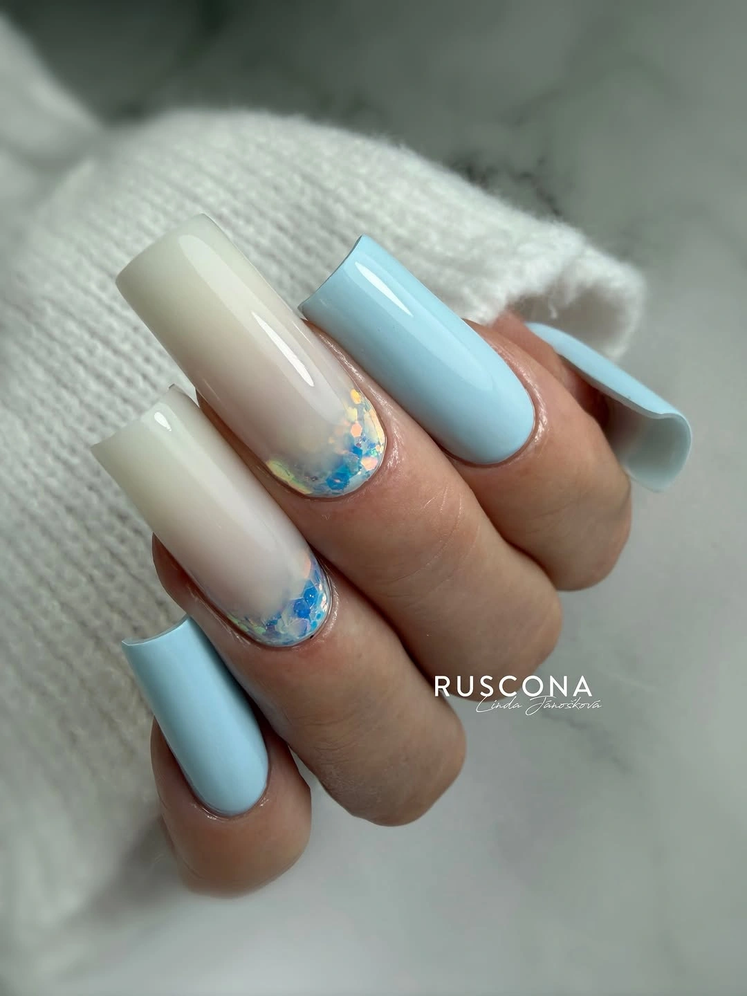 Long square nails alternating ivory and powder blue with glitter