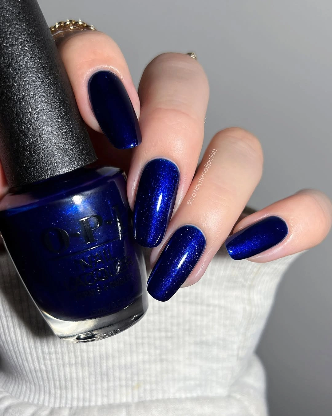 rounded square manicure in deep navy blue with bright blue shimmer