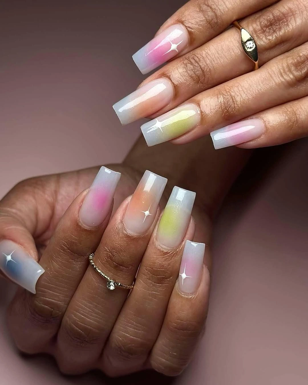 long square manicure featuring milky white bases, soft pastel aura centers, and white star highlights
