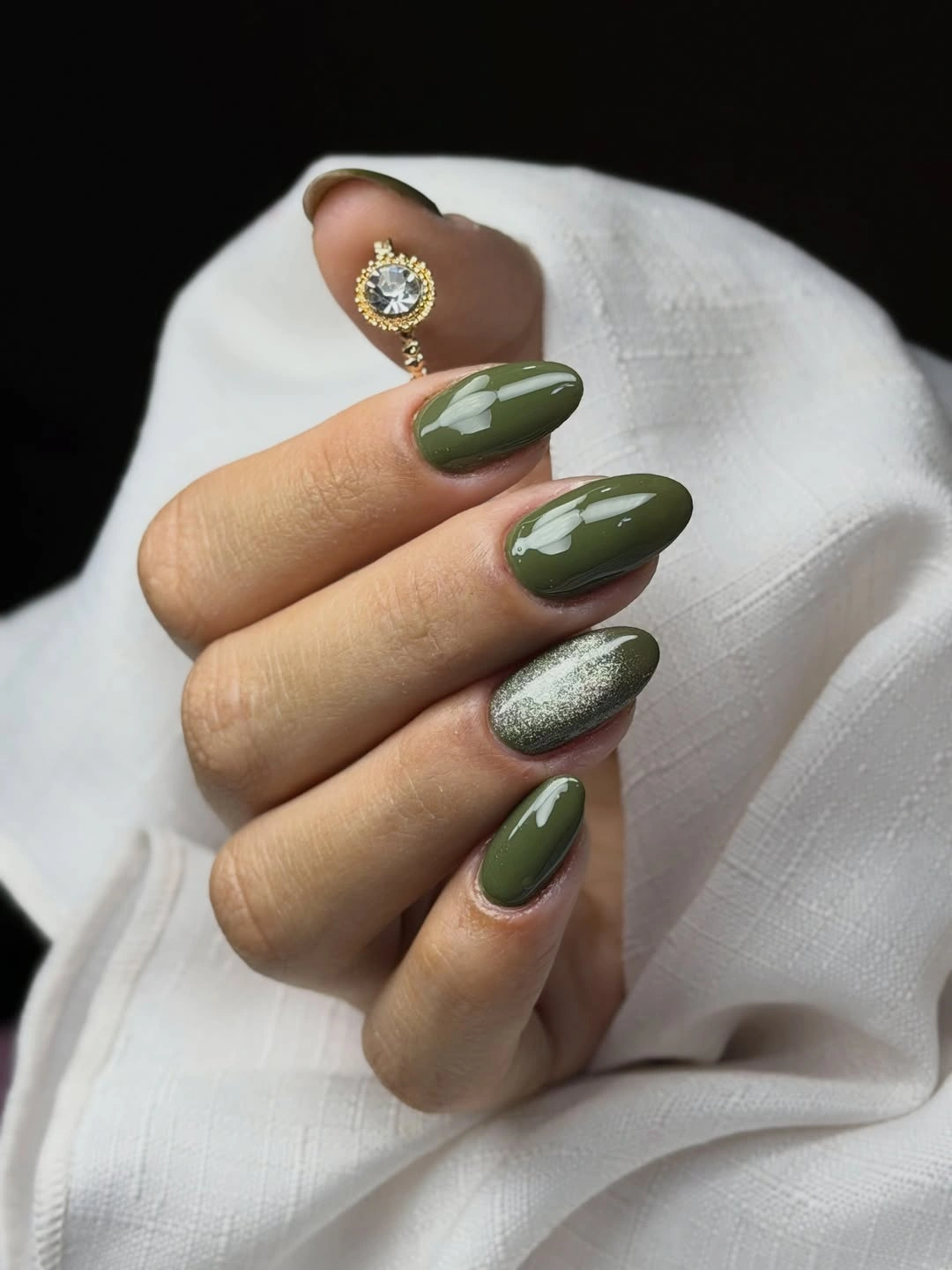 dark olive almond nails with one pale reflective accent